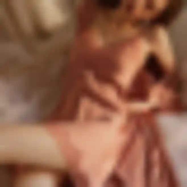 A woman in red sheer dress is lying seductively on a bed with sheer blanket.