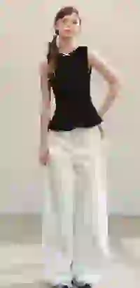 Modelka w czarnym podkoszulku z peplum i białych spodniach z szerokimi nogawkami pozuje w studiu. Szablon modelu zmieniacza ubrań AI.