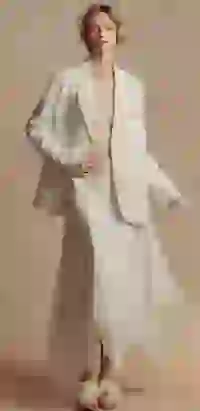 Modelka w dużej białej jednorzędowej marynarce i białej spódnicy maxi z asymetrycznym dołem pozuje w studiu. Szablon modelu zmieniacza ubrań AI.