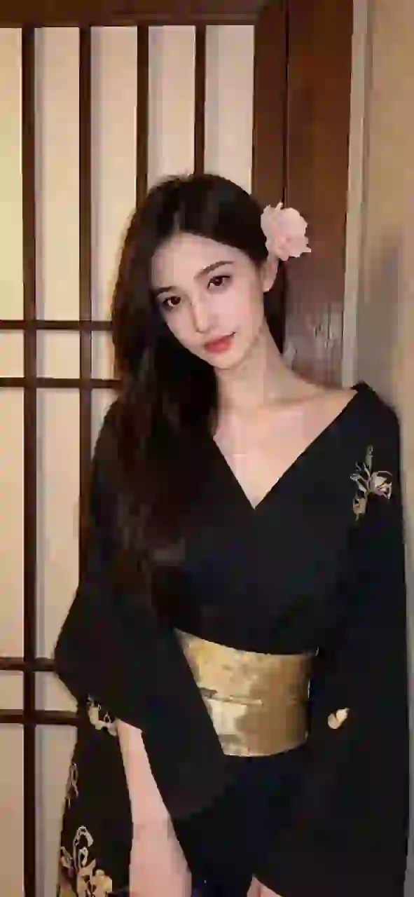 和室でポーズをとる黒い着物を着たアジア人女性。