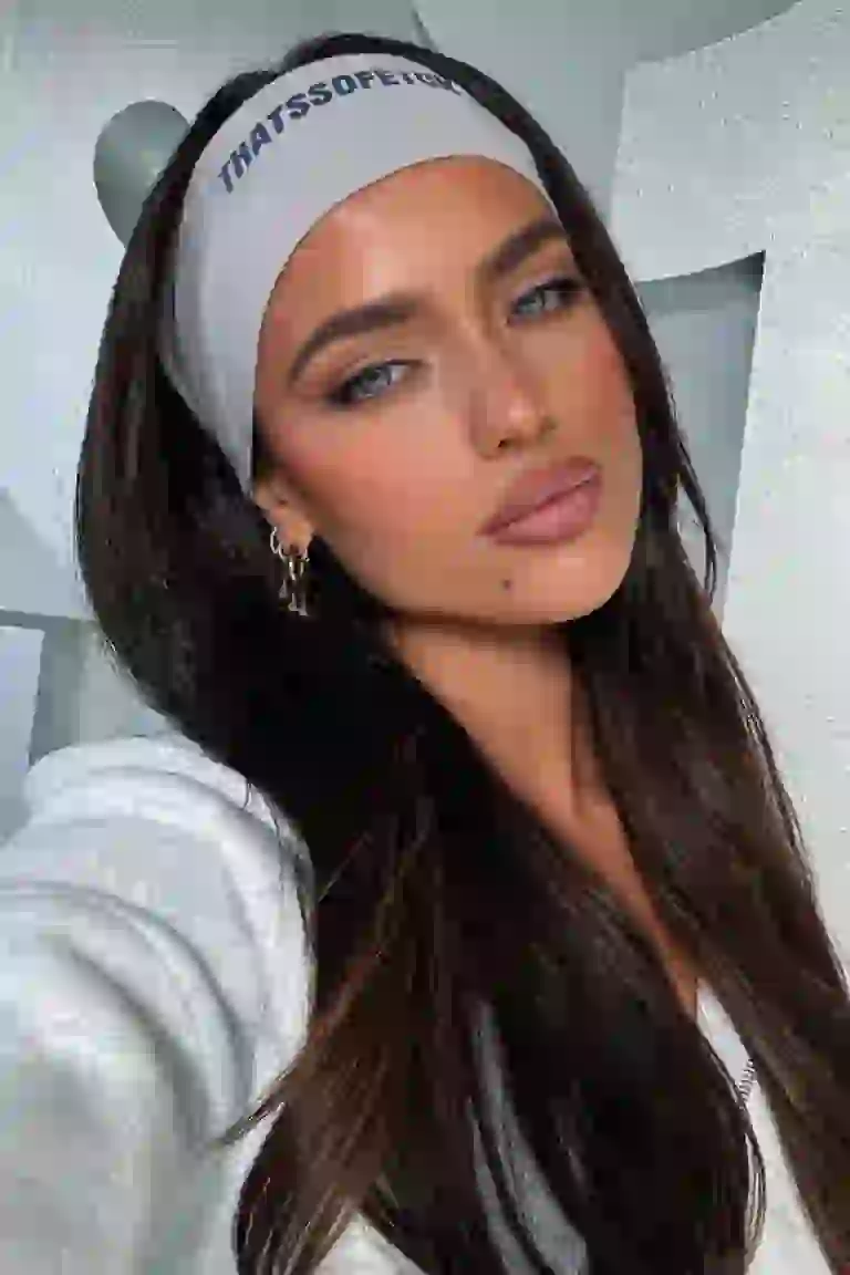 Mujer en deportes casuales grises afuera posando con confianza.