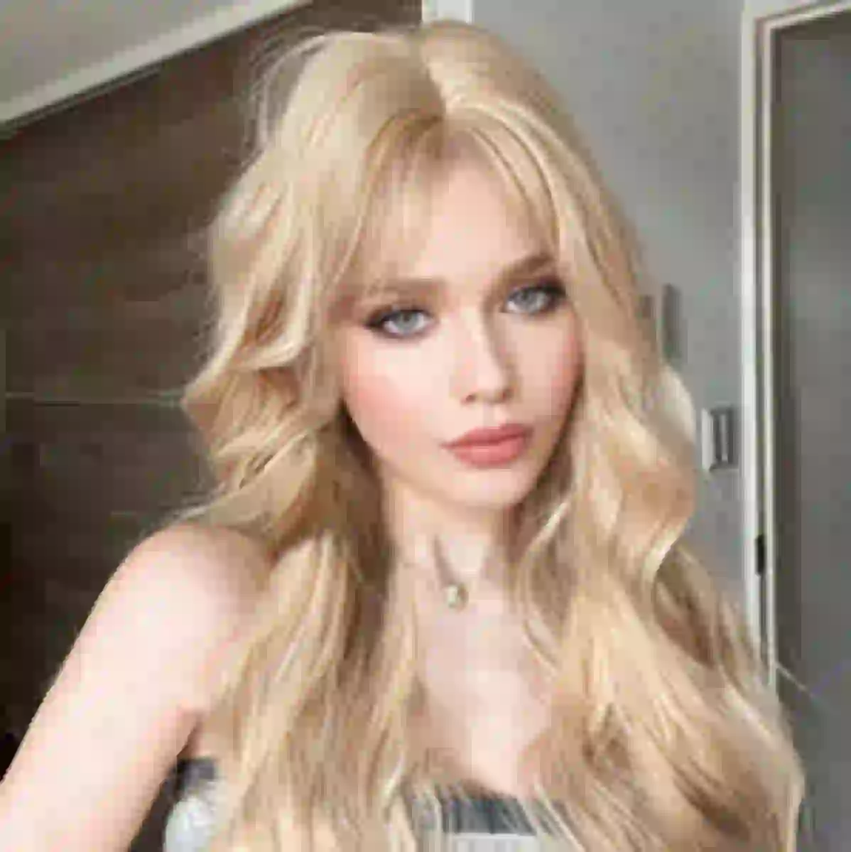 Vrouw met blond golvend haar poseert binnenshuis. Modelsjabloon voor photo face swap.