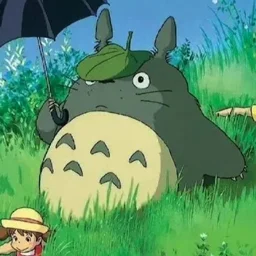 Totoro di un film di Miyazaki con in mano un ombrello e due bambini si nascondono giocosamente in un campo lussureggiante ed erboso sotto un cielo blu brillante.