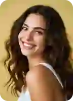 Retrato profissional de uma mulher de blazer cinza, sorrindo, com um fundo neutro e limpo.